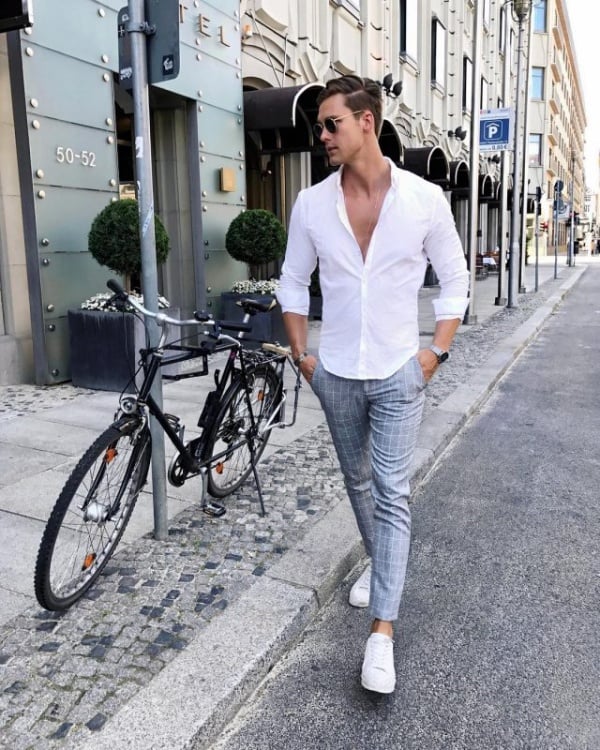 Wearing a white shirt a black tie gray pants a college black male  student is standing by a railing on campus confidently looking at you   Portrait of College Student  Stock